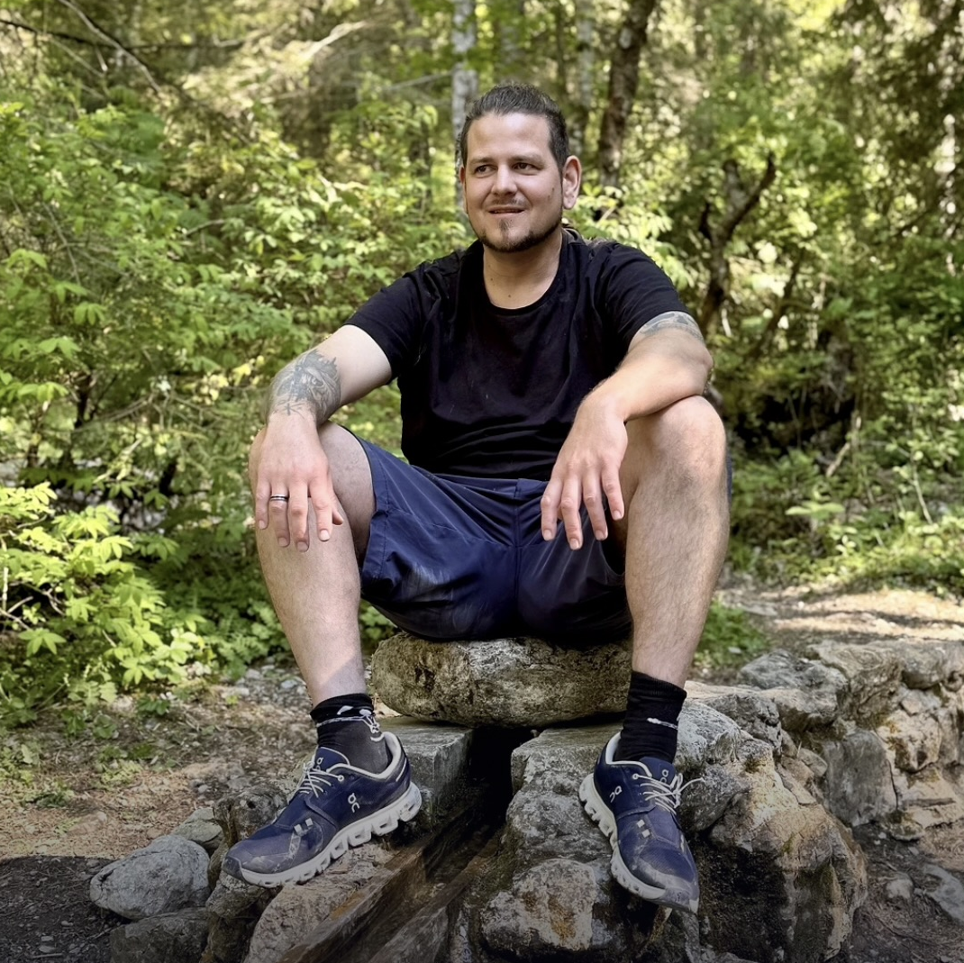 Sebastian Bürgy sitzt draussen in der Natur